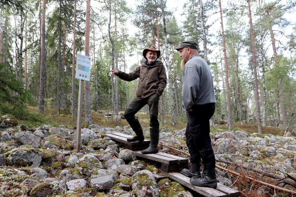 Alkkianvuori oli noin 8900  -7200 eaa yksinäinen saari, jota ympäröi Ancylusjärvi. Rantakivikolla ajasta kertovan taulun vierellä Hannu Latvajärvi ja Juha-Matti Palmi.