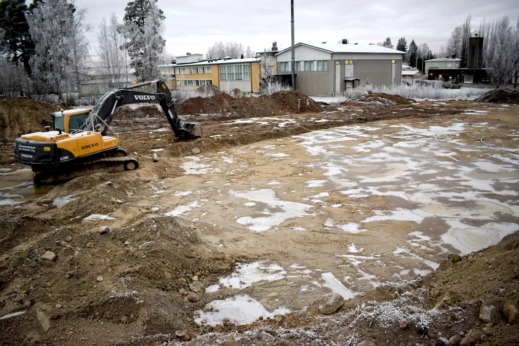 Jääkiekkokaukalon pohjatöitä peltoalueen entisestä metsäsaarekkeesta päin kuvattuna.